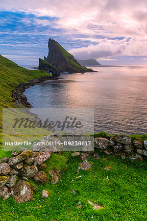 Sunset on the calm ocean and Drangarnir rock, Vagar island, Faroe Islands, Denmark, Europe