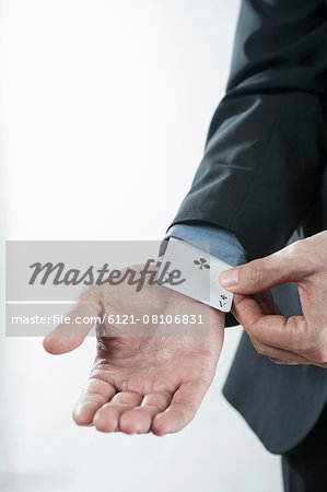 Businessman pulling an ace from sleeve, Bavaria, Germany Businessman pulling an ace from sleeve, Bavaria, Germany