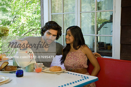 Man pouring juice for woman