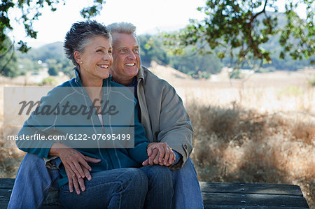 Happy couple sitting on picnic table