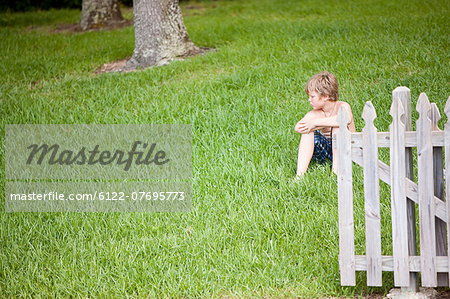 Boy sitting on green grass