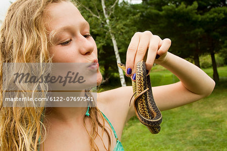 Teenage girl holding small snake