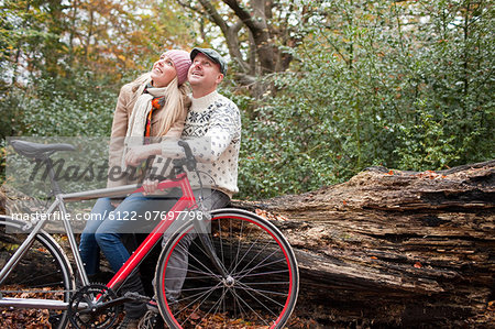 Couple sitting on log with bike