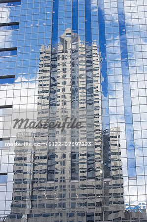 Building reflected in glass of skyscraper