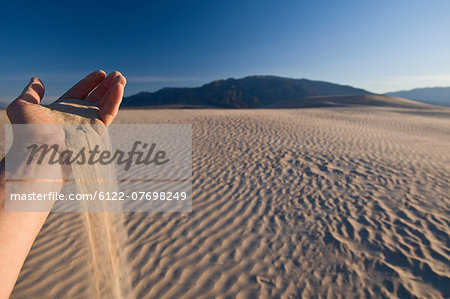 Hand holding sand in Death Valley National Park, California, USA