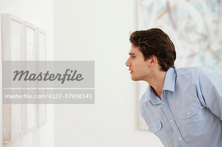 Young man looking at picture in art gallery