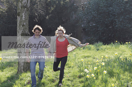 Couple walking hand-in-hand in park