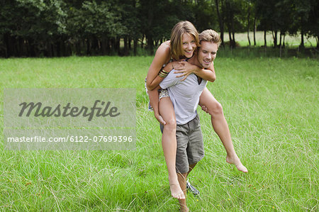 Man carrying girlfriend in field