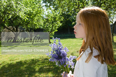 Girl holding flowers in backyard