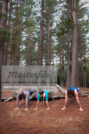 Runners doing push-ups in forest