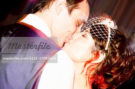 Newlywed couple kissing at reception