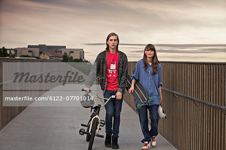Teenagers with bicycle and skateboard