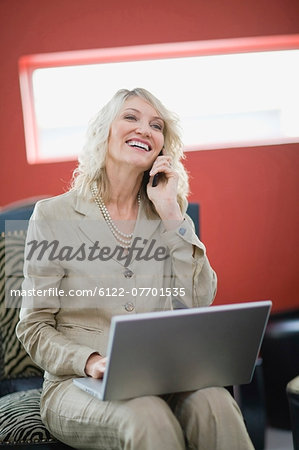 Businesswoman on phone using laptop
