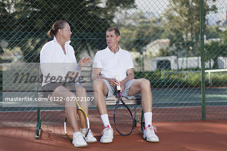 Older couple talking on park bench