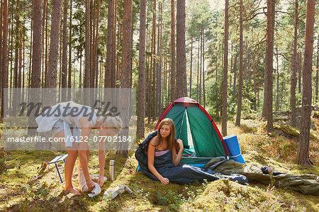 Women setting up campsite in forest