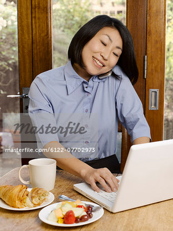 Businesswoman eating and working