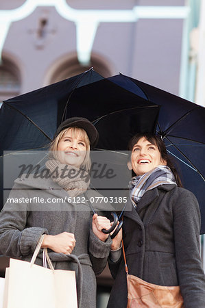 Women under umbrellas on city street