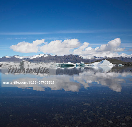 Snowy mountains reflected in still lake