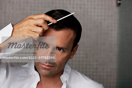 Man combing his hair in bathroom