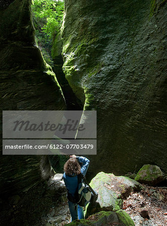 Woman taking pictures of rocky cavern