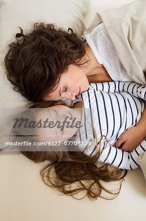 Mother and daughter relaxing in bed