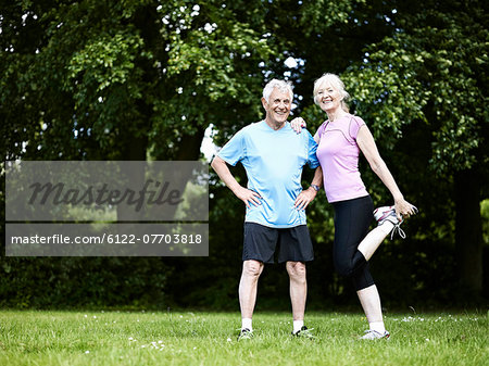 Older couple stretching in park