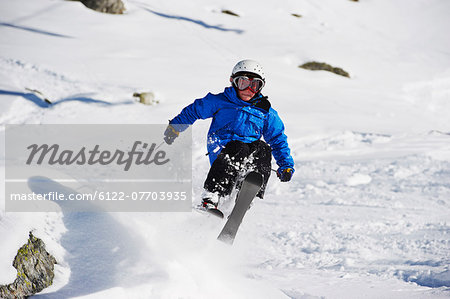 Boy skiing on snowy mountainside