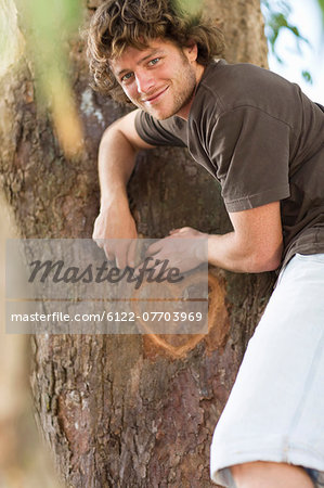 Smiling man carving heart in tree