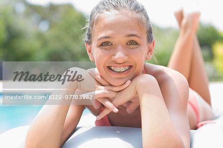 Teenage girl in braces relaxing by pool