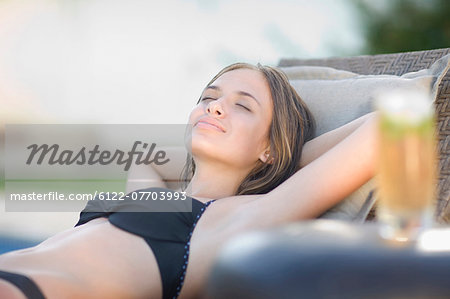 Young Teenage Girl In A Swimsuit Wearing Braces Smiles On A Beach