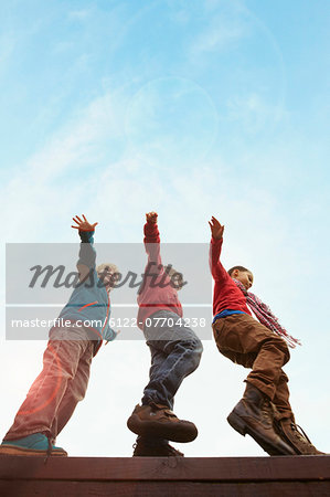 Children balancing on wooden wall