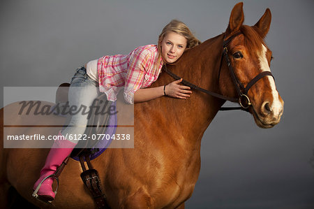 Teenage girl riding horse outdoors