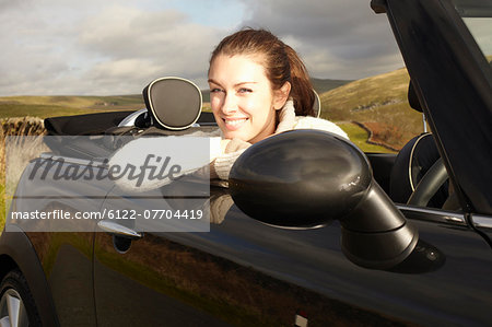 Smiling woman leaning out of convertible