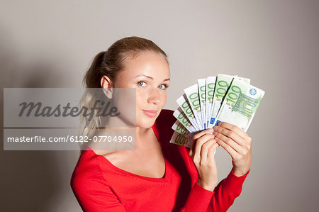 Woman holding stack of Euros