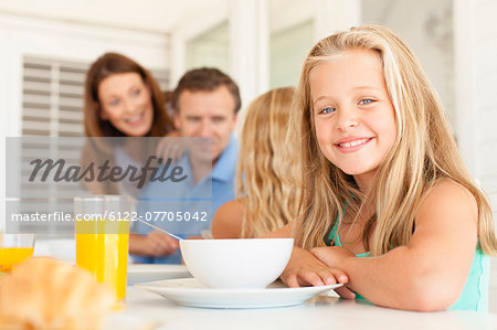 Smiling girl sitting at breakfast table