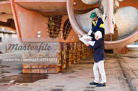 Workers talking in propeller on dry dock