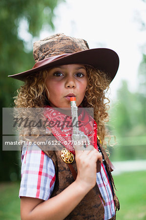 Girl in cowboy hat with toy pistol