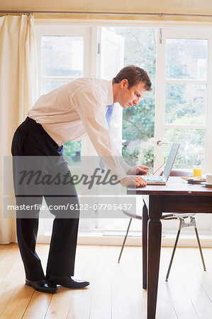 Businessman using laptop at breakfast