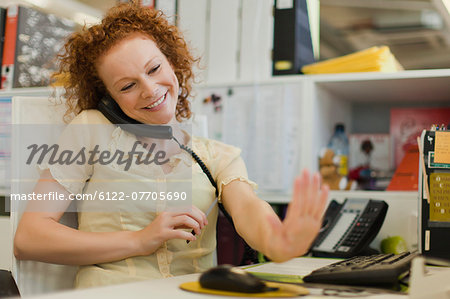 Businesswoman talking on phone at desk