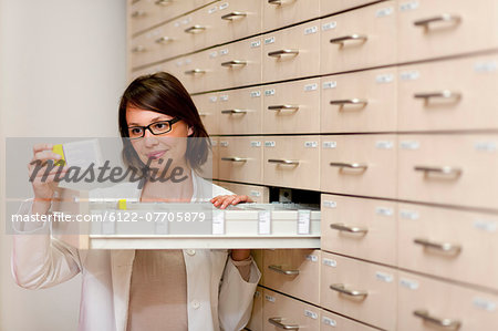 Pharmacist browsing medicine in drawer