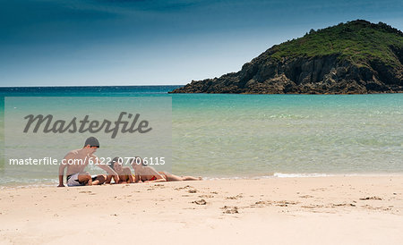 Friends relaxing on sandy beach