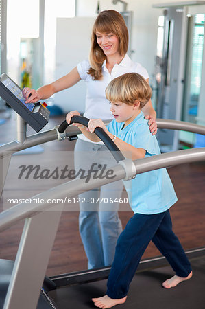 Trainer working with boy in gym