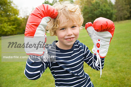 Boy playing with boxing gloves outdoors