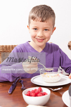 Boy eating breakfast at table