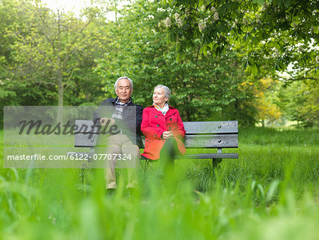 Older couple sitting on park bench