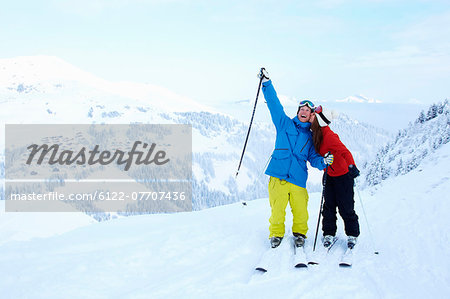 Skiers celebrating on snowy mountaintop