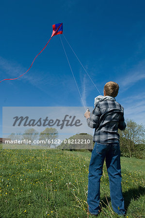 Boy flying a kite in field