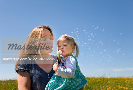 Mother and daughter standing in field