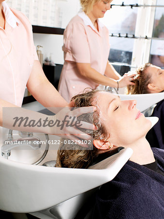 Hairdressers washing women's hair