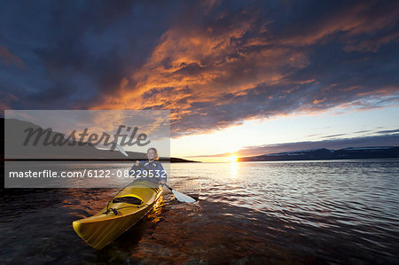Woman kayaking in still lake